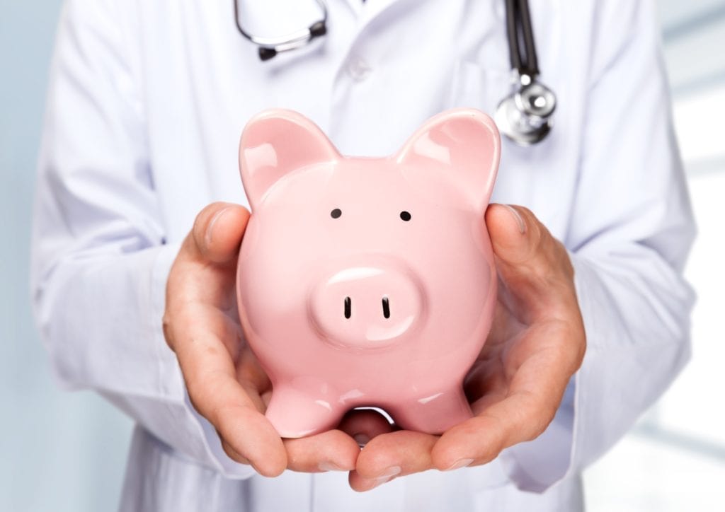Physician holding a piggy bank symbolizing the Medicare Cost Report