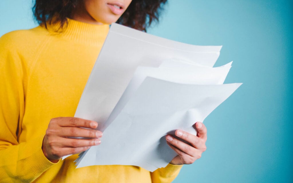 Woman holding a stack of papers symbolizing white papers