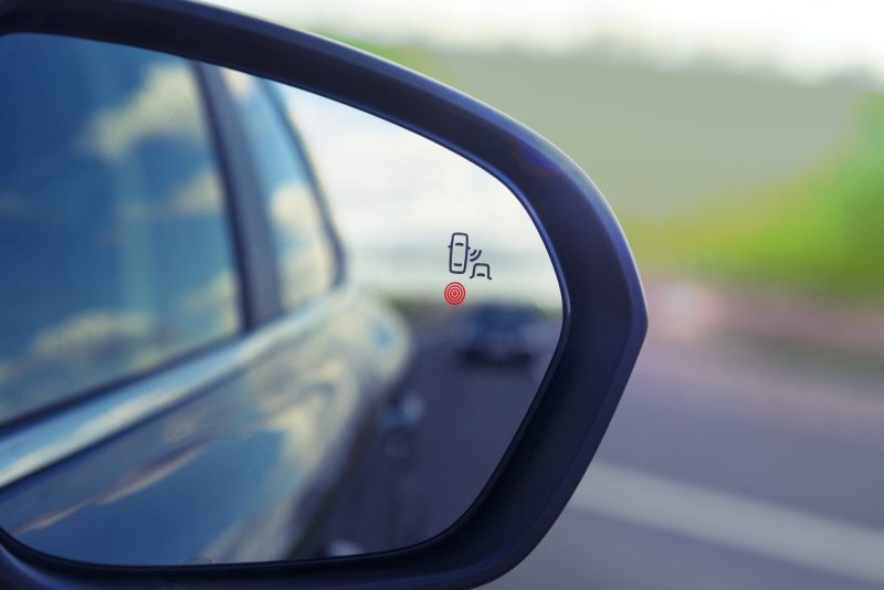 Blind Spot Monitoring system warning light icon in side view mirror of a modern vehicle