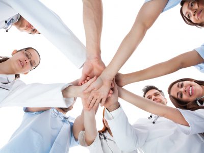 Doctors and nurses stacking hands. Isolated on white